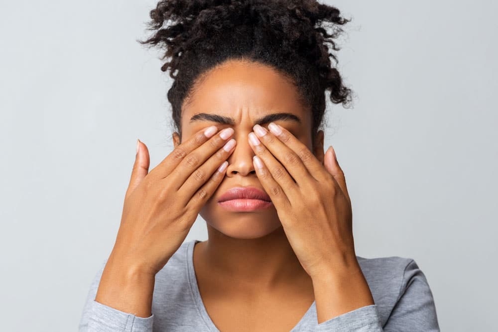 Woman with dry, irritated eyes exploring home eye remedies for dry eyes.