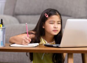 close-up of a child squinting at a laptop screen illustrating hyperopia as a cause of blurry vision