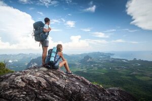 Elevation and retina surgery: two hikers overlooking a mountain valley, illustrating the impact of altitude changes on postoperative eye recovery
